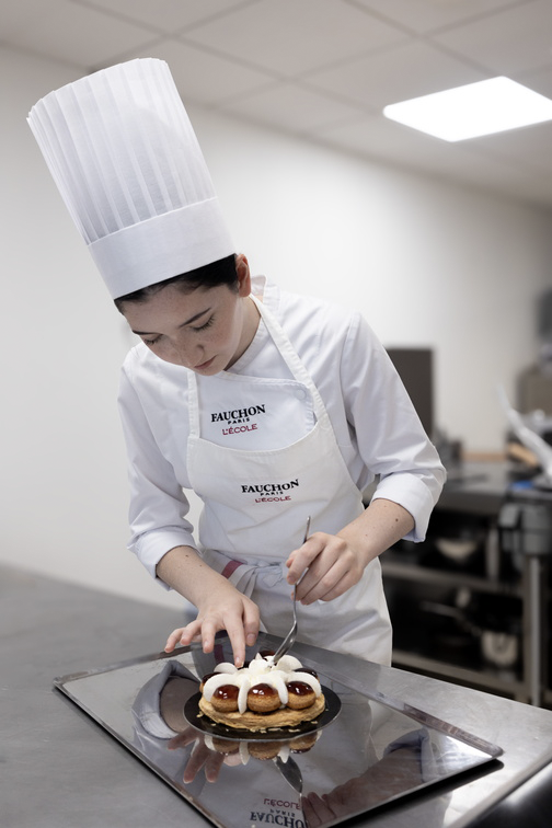 éléve en tenue de cuisine réalisant un st honoré