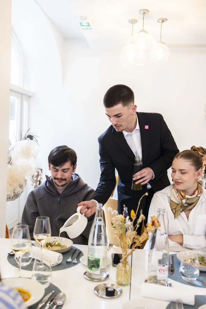 étudiant serveur qui sert des clients au restaurant