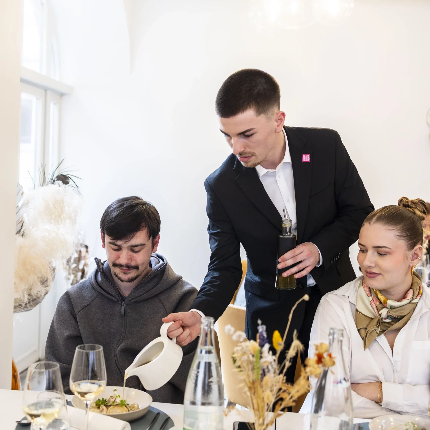 étudiant serveur qui sert des clients au restaurant