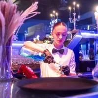 Une élève au bar préparant un cocktail