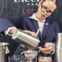 Élève préparant un cocktail avec un shaker.