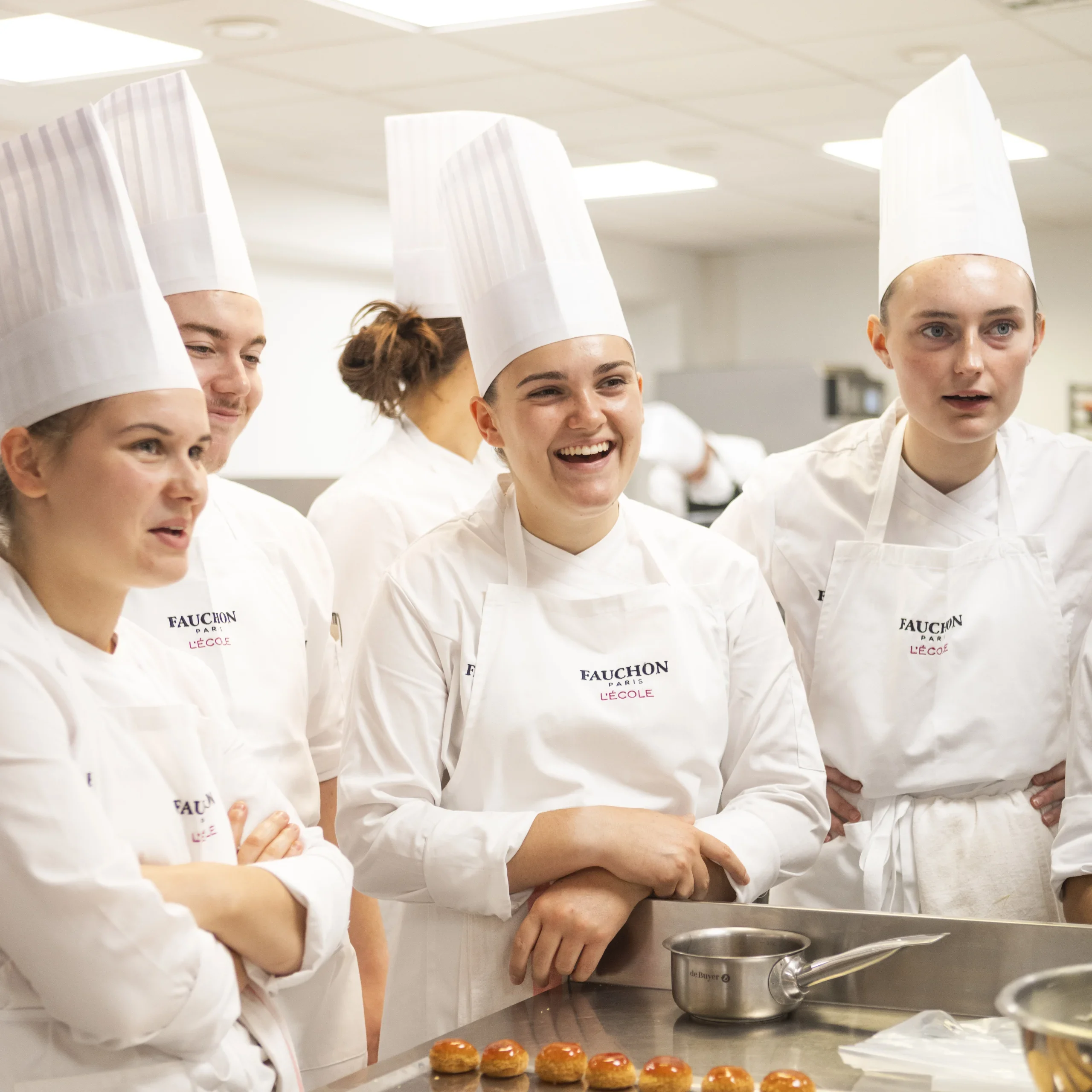 étudiants en tenue de cuisine qui rigolent